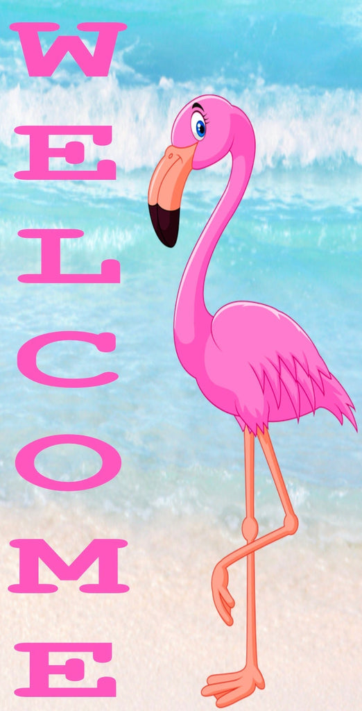 12 inch by 6 inch vertical metal wreath sign has welcome printed in pink with a pink flamingo striking a post and is set against a beach themed background