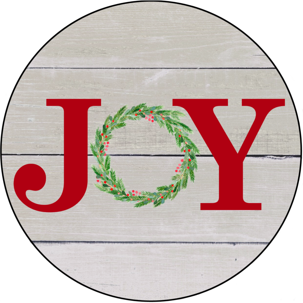 8 inch round wreath sign with Joy printed in red with a simple wreath replacing the letter "o" atop an aged wood background.