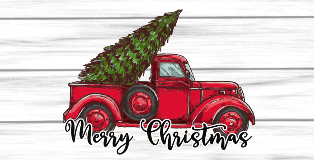 12 inch metal wreath sign with an antique red truck hauling a tree with Merry Christmas printed in black against a white shiplap background